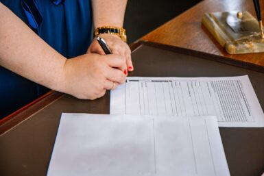 personne tenant un stylo et écrivant sur du papier