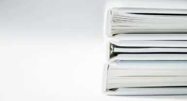 Une pile de dossiers épais sur une surface blanche