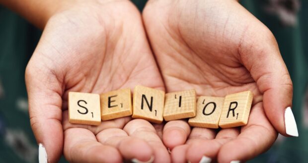 Senior dice on person's palm