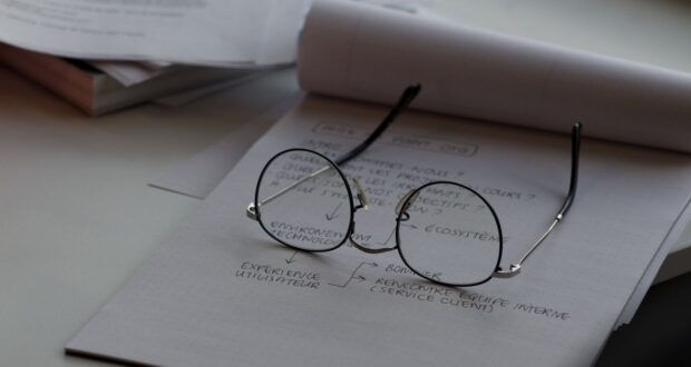 black framed eyeglasses on top of white printing paper