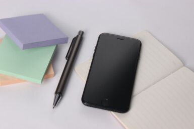black iphone 4 beside black click pen