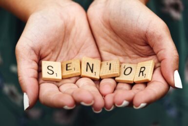 Senior dice on person's palm