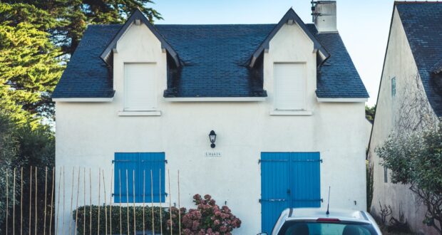 blue and white concrete house with blue metal gate