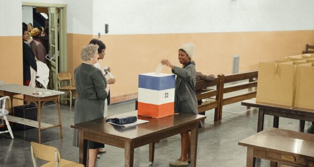 A young African American woman casting her ballot in 1964