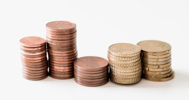 stacked round gold-colored coins on white surface